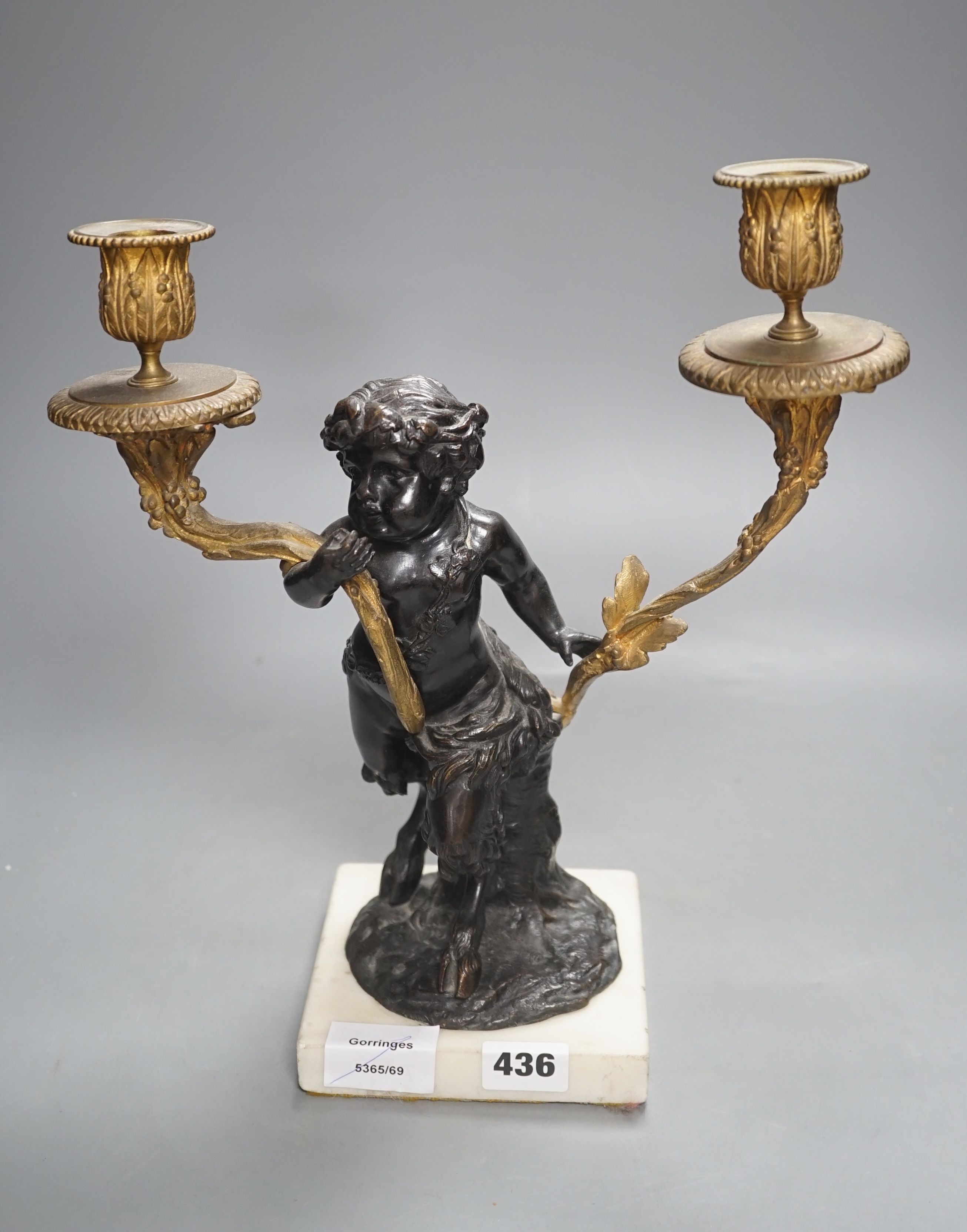 A bronze and ormolu putto two branch candelabrum, 33 cms high.